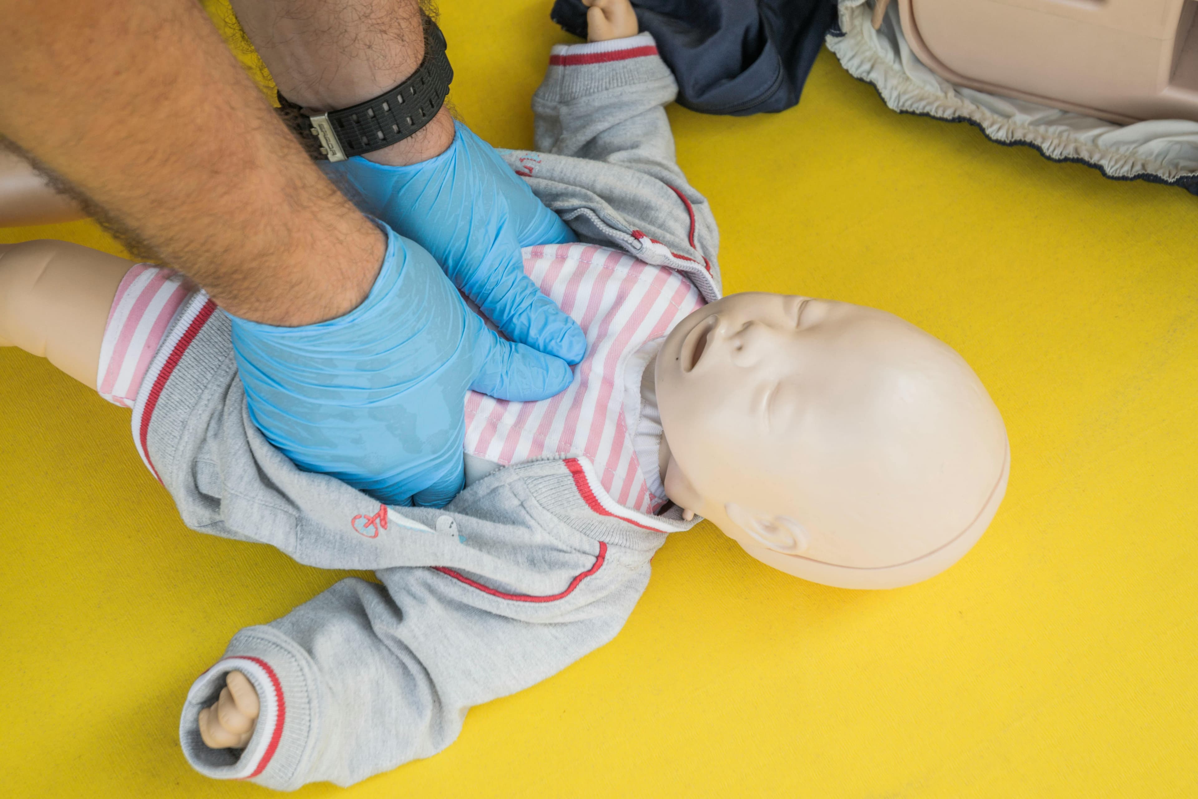Infant CPR demonstration showing proper hand placement and rescue breaths